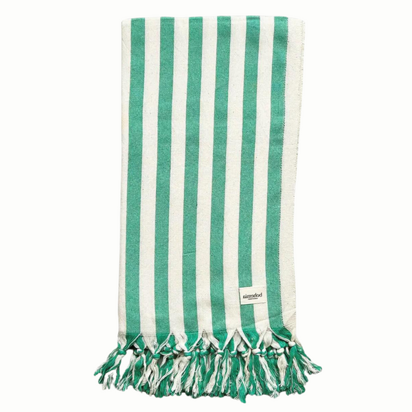 A cotton beach towel with large green stripes and a tassel fringe.