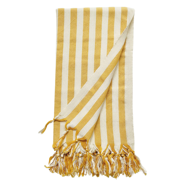 A cotton beach towel with large yellow stripes and a tassel fringe.